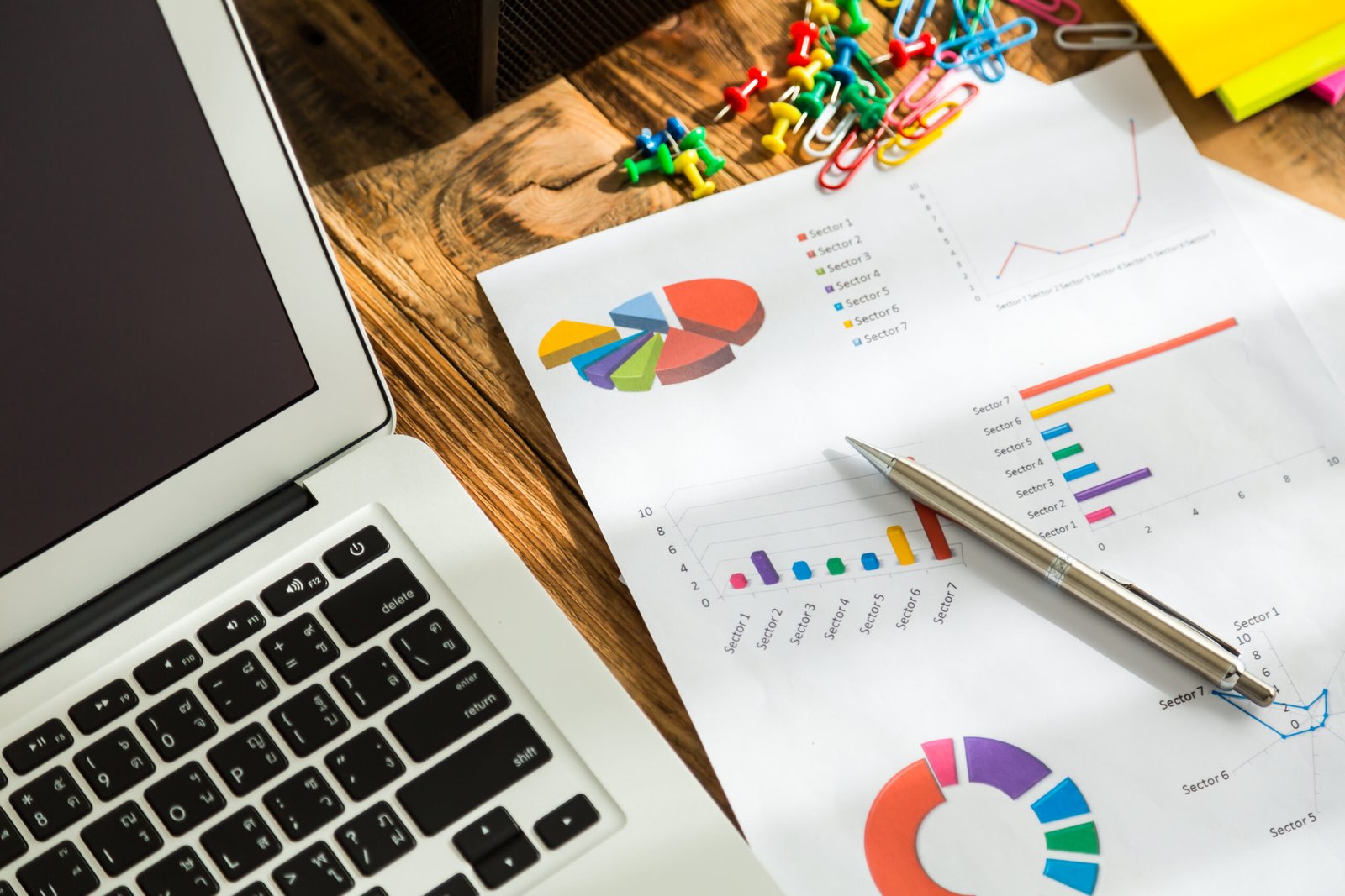 Financial charts on the table with laptop